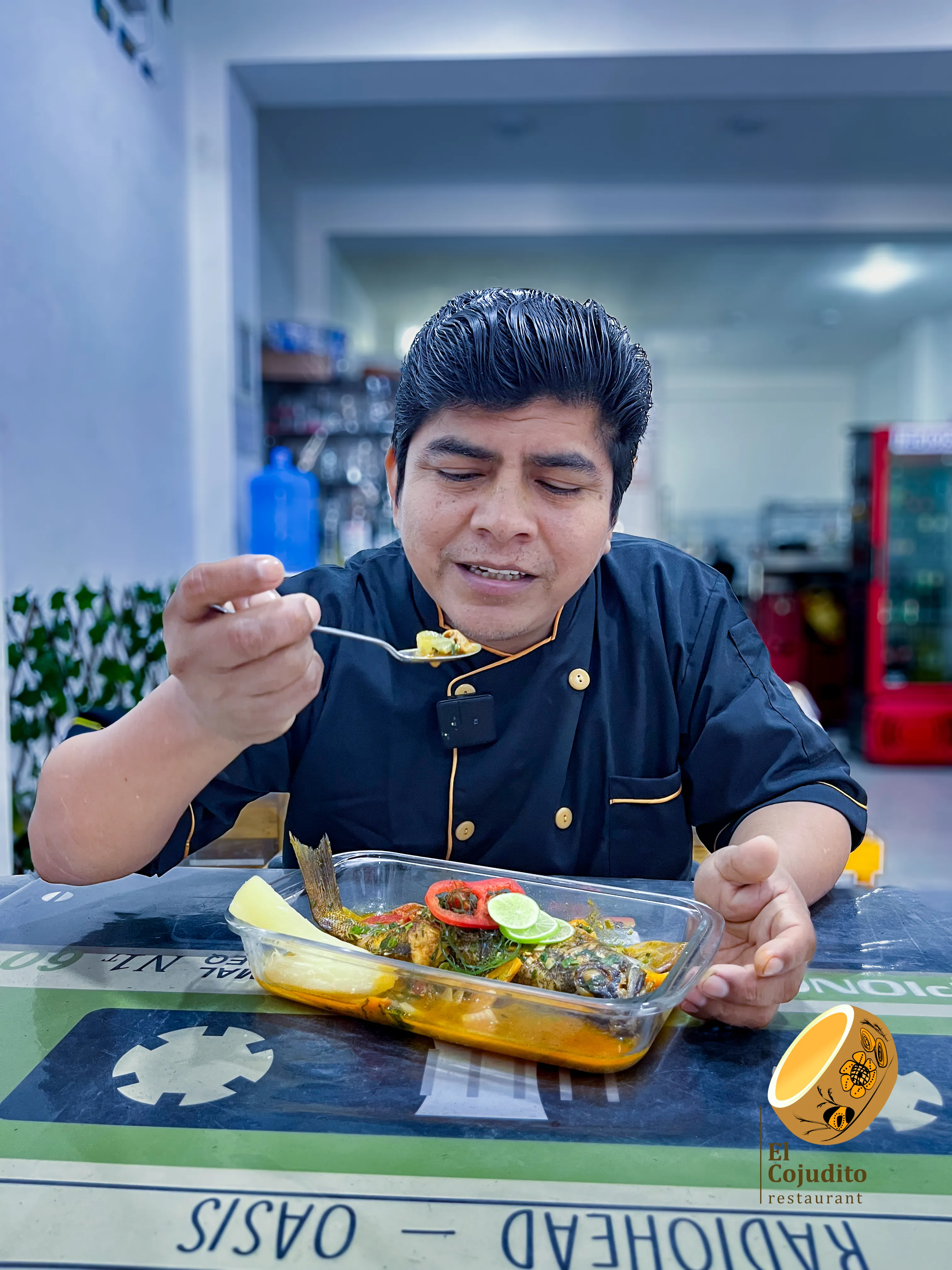 Hombre prueba un plato de pescado acompañado por salsa y vegetales