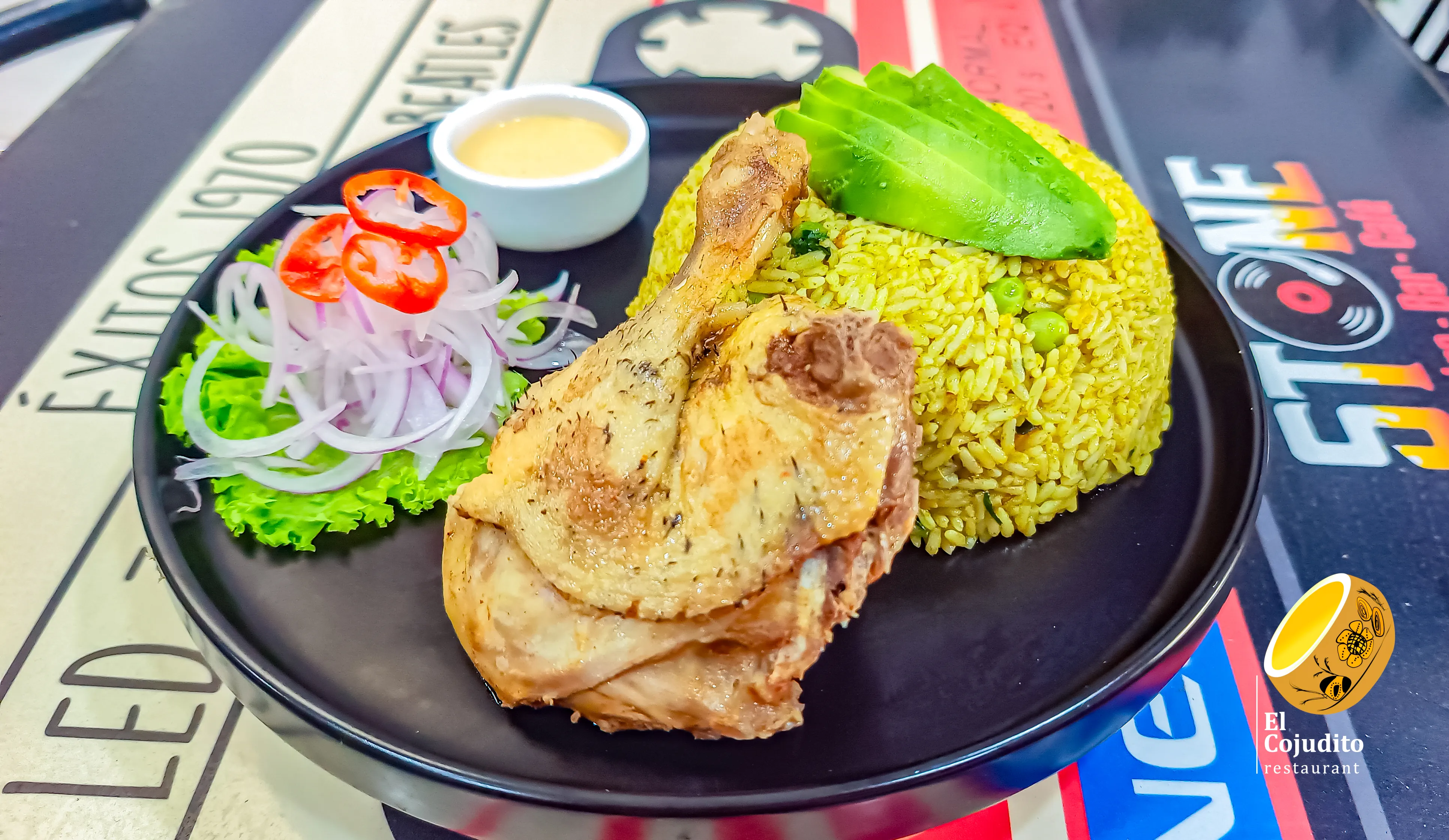 Plato de arroz con una presa de pato, aguacate, cebolla y dos salsas